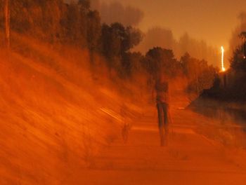 Man on snow covered trees against sky during sunset