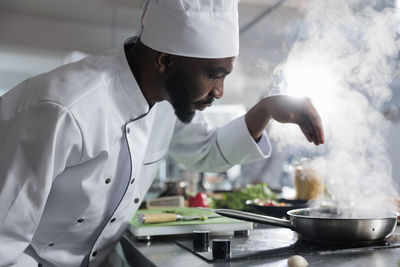 Midsection of man preparing food in workshop