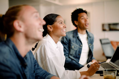 Side view of a smiling young woman using smart phone