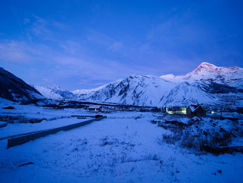 Scenic view of snowcapped mountains against blue sky