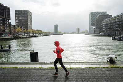 Full length of woman by river in city