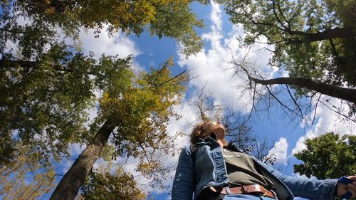 Directly below shot of woman standing amidst trees 