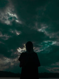 Low angle view of silhouette man standing against sky