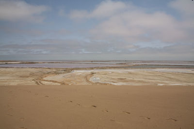 Salt flats at desert against sky