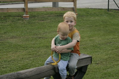 Siblings playing on seesaw at playground