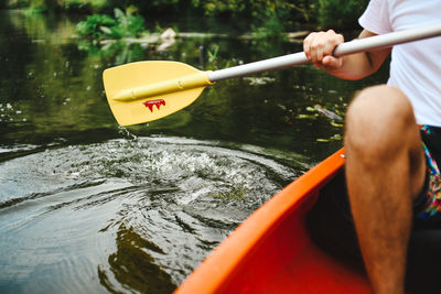 Midsection of man holding boat in river