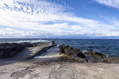 Rocks on beach against sky