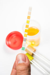 Close-up of person holding drink against white background