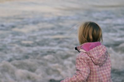 Rear view of woman standing in sea