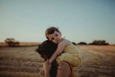 Portrait of woman standing on land against clear sky during sunset