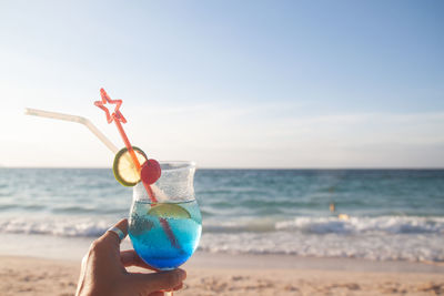 Person holding ice cream on beach