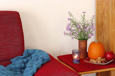 Flower vase on table against wall at home