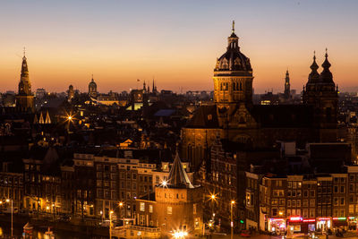 Basilica of st nicholas and cityscape against sky at dusk