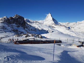 Scenic view of snowcapped mountains against clear blue sky