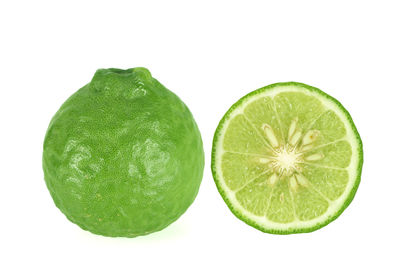 Close-up of green fruits against white background