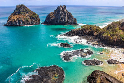 Scenic view of rocks in sea against sky