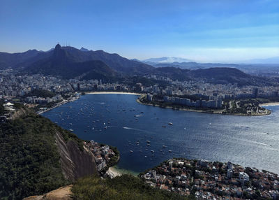 High angle view of city by sea against sky