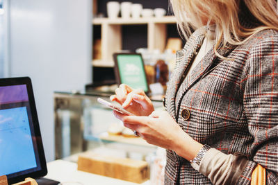 Midsection of woman holding mobile phone