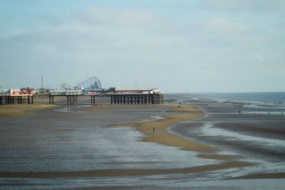 Pier on beach against sky