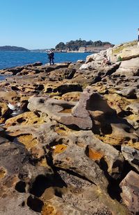 Rocks on beach against clear sky