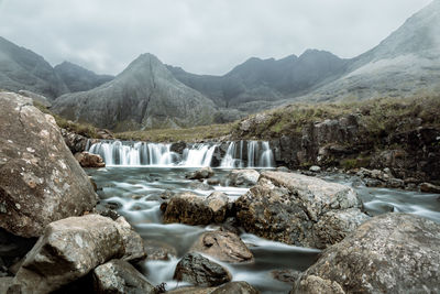 Scenic view of waterfall against mountains