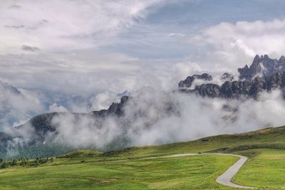 Scenic view of mountain range against cloudy sky