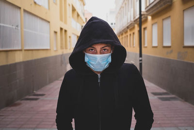 Portrait of teenage girl standing against wall