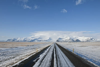 Straight highway leading to majestic mountain in iceland