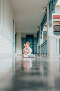 Surface level of baby boy sitting on floor in balcony