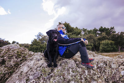 Man sitting with dog on rock