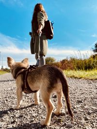 Full length of woman with dog against sky