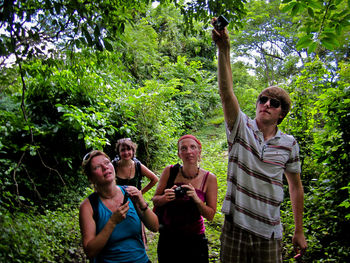 Friends standing on a man in forest