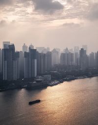 Cityscape by sea against sky