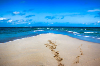 Scenic view of beach against blue sky