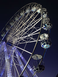 Low angle view of illuminated ferris wheel against sky at night