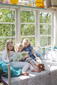 Three girls reading book