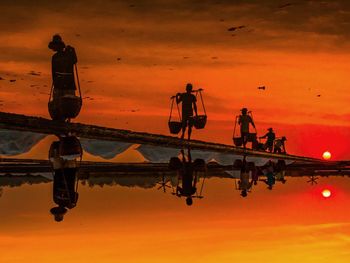 Workers on salt lake at sunset