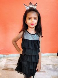 Portrait of girl standing against wall