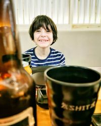 Portrait of smiling boy with drinks on table