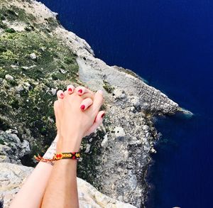 High angle view of couple holding hands over sea