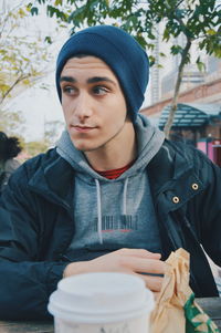 Portrait of young man with ice cream in winter