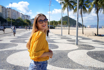 Portrait of attractive smiling woman walking along copacabana beach promenade rio de janeiro, brazil