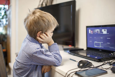 Side view of boy using mobile phone