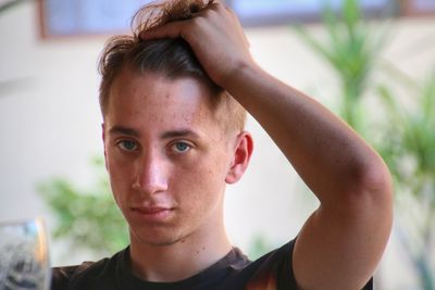 Portrait of young man with hand in hair