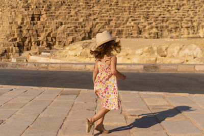 Cute little girl dancing in front of the cheops pyramid on the giza plateau
