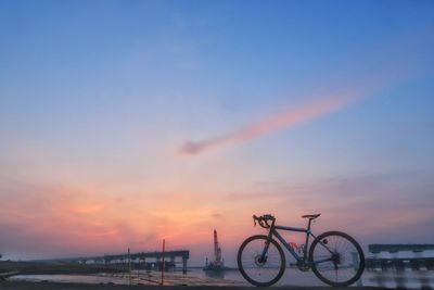 Silhouette bicycle against sky during sunset