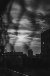 Buildings in city against dramatic sky