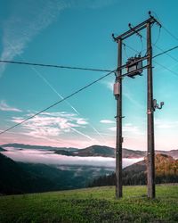 Electricity pylon on land against sky