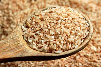 Close-up of rice in wooden spoon