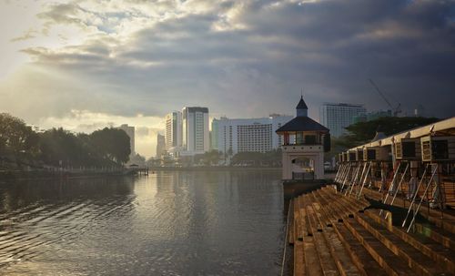 Buildings by lake against sky